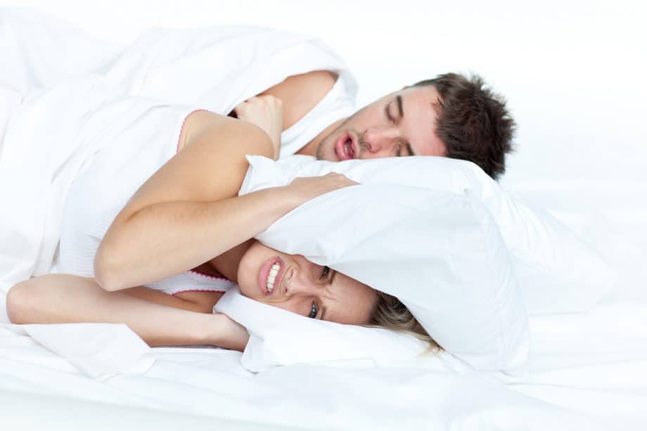 a woman struggles to sleep as her partner snores